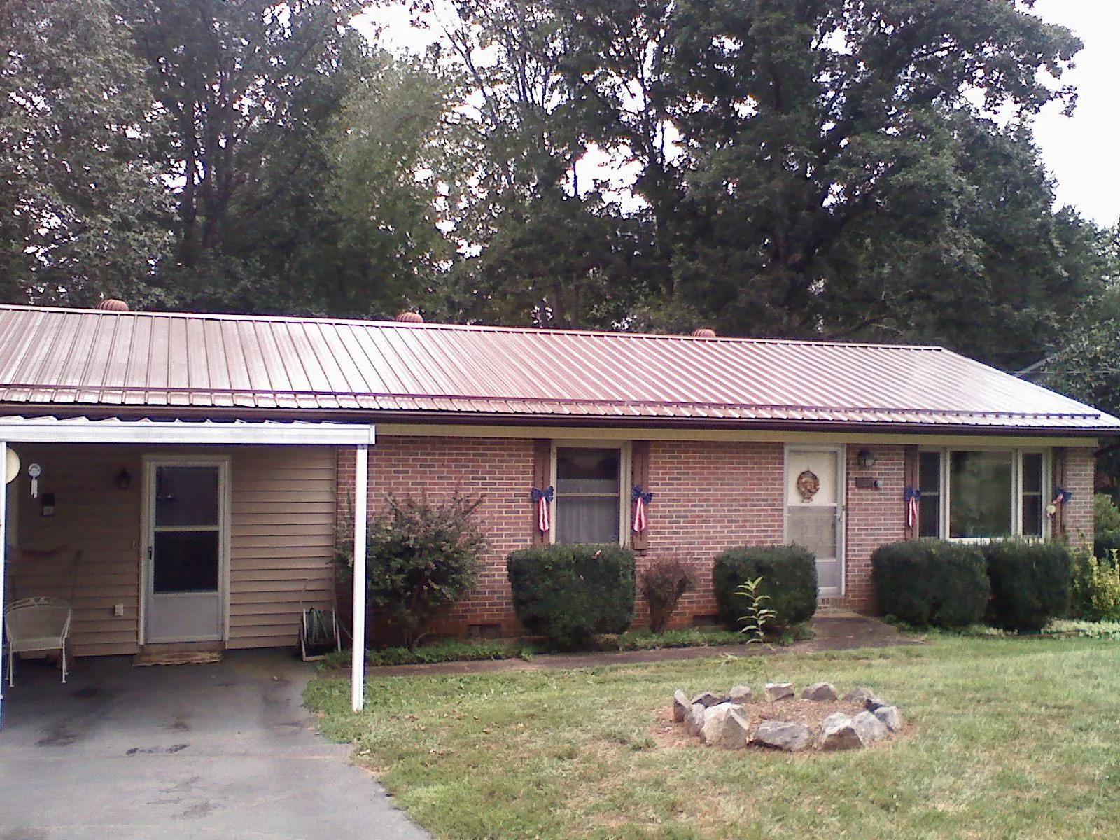 Bronze metal roof and carport on a brick ranch home — Roof Repair work by our crew in Big Rock