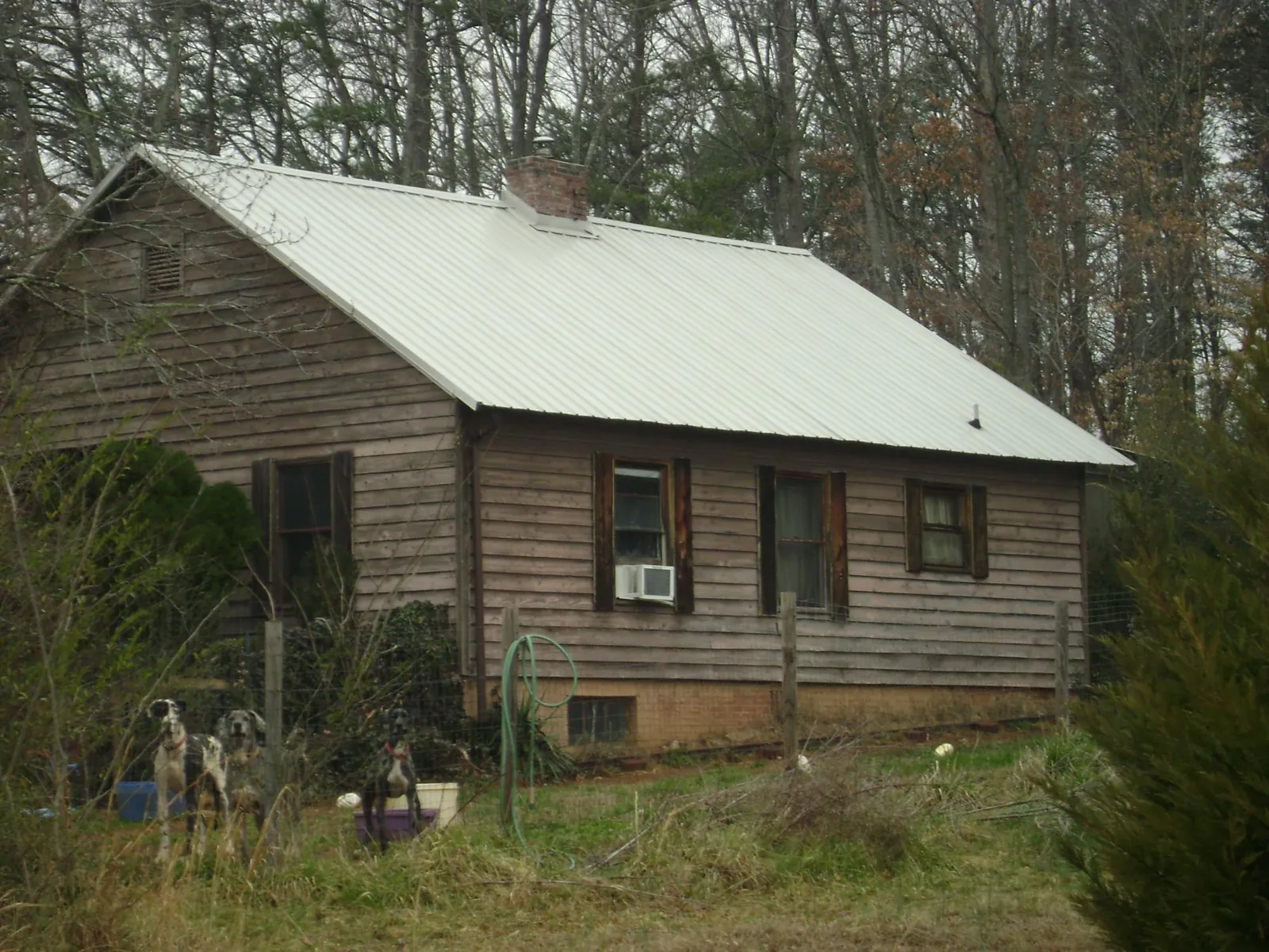 White metal roof on an old wood sided farmhouse, from a Metal Roof Installation job in Big Rock